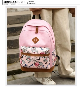 Detail of pink canvas backpack with floral front pocket and brown leather base