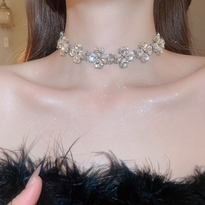Detail of silver heart-shaped crystal necklace worn by a model with elegant shimmering effect