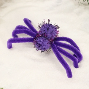 Macro detail of purple Halloween spider hair clip with shiny pink metallic bristles