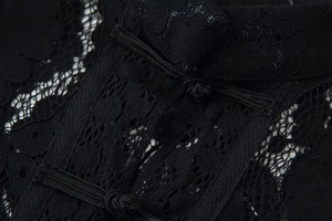 Vue détaillée du tissu en dentelle noire avec des boutons chinois traditionnels et broderie