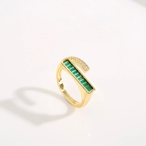 Golden ring featuring emerald green zircon stones and white diamond accents on a white base