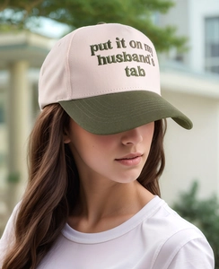 Detail of embroidered lettering on a contrast-color baseball cap worn by a model