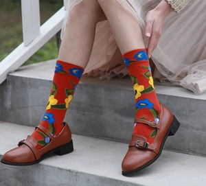 Close-up of red socks with blue and yellow floral patterns paired with Mary Jane shoes