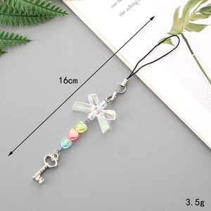 Detail of a butterfly charm phone strap with gradient heart beads and a key pendant
