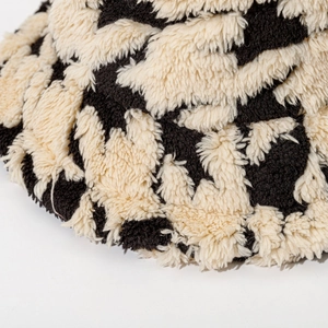 Thick plush houndstooth bucket hat with black and white abstract cow print texture