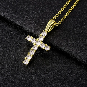 Elegant gold cross pendant necklace with sparkling cubic zirconia on black background
