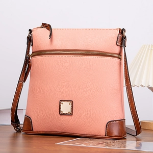Close-up of pink pebble leather texture with brown trim and metallic zipper details