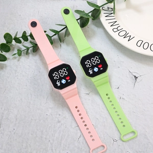 Detail of pink and green LED electronic watches with astronaut icons and silicone straps