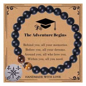 Detail of handmade beaded bracelet with matte black beads, tiger eye and compass pendant