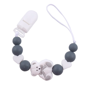 Detail of grey and white silicone pacifier clip with heart beads and white bear charm