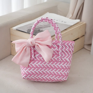 Detailed texture of pink and white woven basket bag with a large decorative silk bow