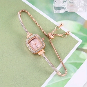 Close-up of rose gold square watch with rhinestone bezel and elegant chain bracelet strap