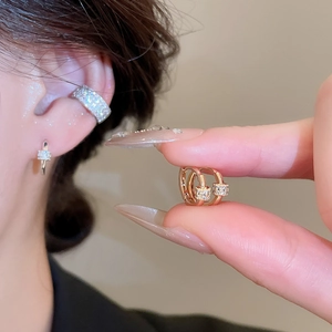 Close-up of 18k gold-plated zircon hoop earrings shown on model and held in hand