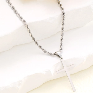 Polished silver stainless steel cross pendant on twist rope chain over white stone decor