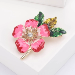 Macro detail of enamel flower brooch with pink gradient petals and sparkling rhinestone