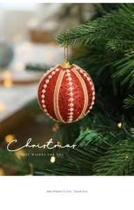 Detail of red glitter Christmas ball with pink beads hanging on a tree with bokeh light