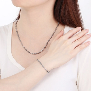 Chic silver cylinder link chain necklace and bracelet set shown on model in studio light