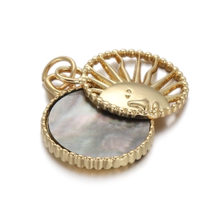 Detailed view of a gold sun pendant featuring dark grey shell inlay and beaded edges