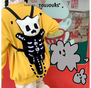 Foto callejera de una mochila de peluche de monstruo negro y blanco con diseño de calavera