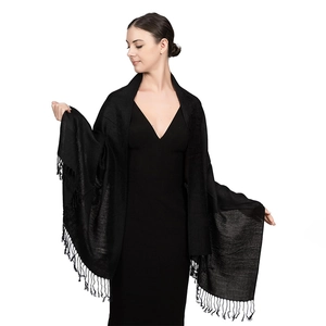 Dettaglio di elegante scialle nero simil cashmere con frange sottili e trama jacquard raffinata