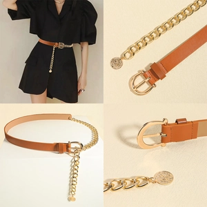 Detail of a brown leather belt with large gold chain links and a vintage coin charm