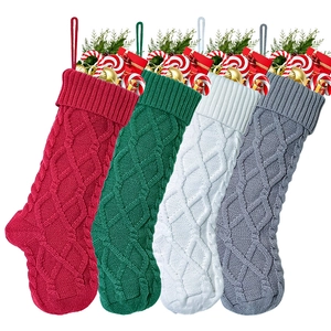 Detailed view of four colorful cable-knit Christmas stockings with holiday gift fillings