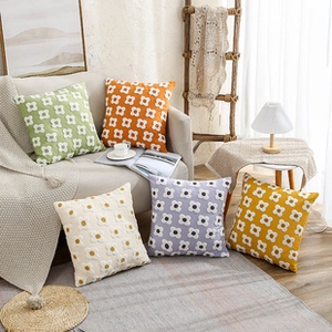 Detail of colorful floral bouclé pillows in green orange and beige for home decor
