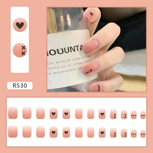 Set matte perzikroze kunstnagels met hart- en kruispatronen volledige detailweergave