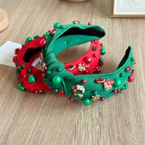 Detail of wide knotted Christmas headband with rhinestones, pearls and festive charms