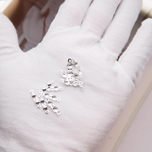 Macro shot of 925 sterling silver DIY jewelry clasp components on white glove