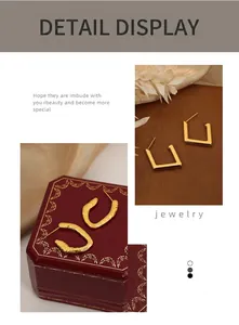 Close-up of vintage geometric 18K gold-plated titanium earrings in luxury red gift box
