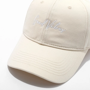 Detail of Good Vibes embroidery and cotton twill texture on beige baseball cap