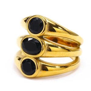 Detail of a triple-layered gold band ring featuring oval and round black zircons