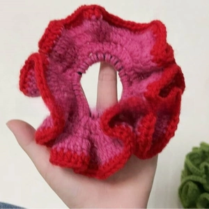 Detail view of handmade ruffled hair scrunchie with red and pink crochet knit layers
