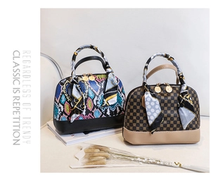 Detail view of two shell handbags with snakeskin and monogram patterns and silk scarves