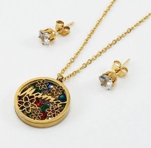Macro detail of gold necklace with Mama pendant filled with colorful crystals and stud earrings