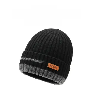 Detail of winter knit beanie showing thick ribbed texture and leather logo patch