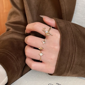 Close-up of gold star ring set with zircon stones on model hand in chic suit