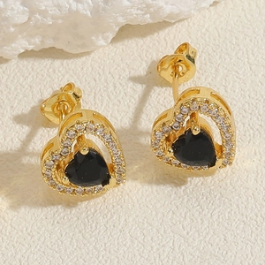 Macro shot of 14K gold plated heart stud earrings with black stone and white zircons