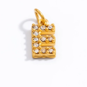 Detail macro view of letter E gold pendant with micro-pave sparkling cubic zirconia stones