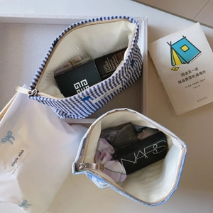 Three-piece travel cosmetic bag set in blue and white stripes with embroidery and zippers