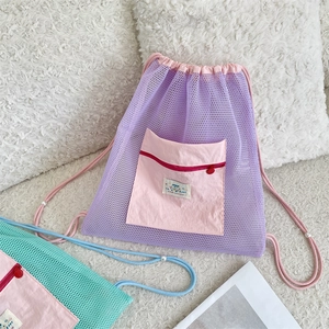 Detail of mesh drawstring backpack with contrast front zipper pocket and happy label