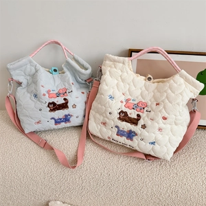 Close-up of quilted heart patterns and cat embroidery on soft cotton tote bags