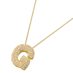 Macro shot of gold-plated letter G pendant fully paved with sparkling cubic zirconia gems