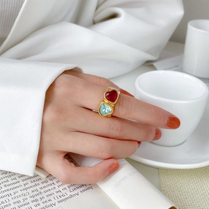 Close-up of a double heart gemstone ring in gold worn by a model in elegant setting