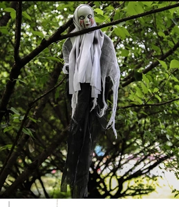 Detail of hanging Halloween ghost with a skull face and red blood marks on a white shroud