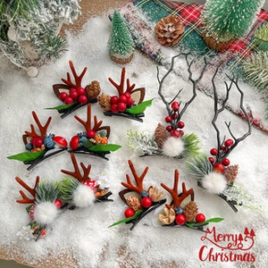 Detailed view of Christmas reindeer antler hair clips with pine cones and red berries
