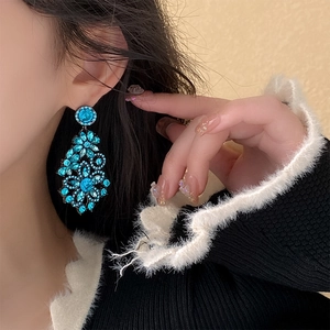 Blue crystal flower drop earrings styled on model showing intricate rhinestone details