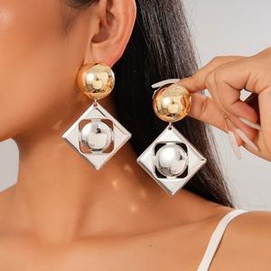 Minimalist geometric earrings with golden spheres and silver rhombus frames on model