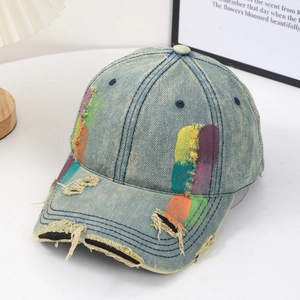 Distressed denim baseball cap with colorful patchwork graffiti in light blue wash